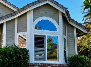Combination replacement windows with an arched picture window installed on a Sacramento home exterior.