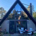 Modern A-frame home featuring large custom picture windows and black-framed patio doors installed by Best Exteriors.