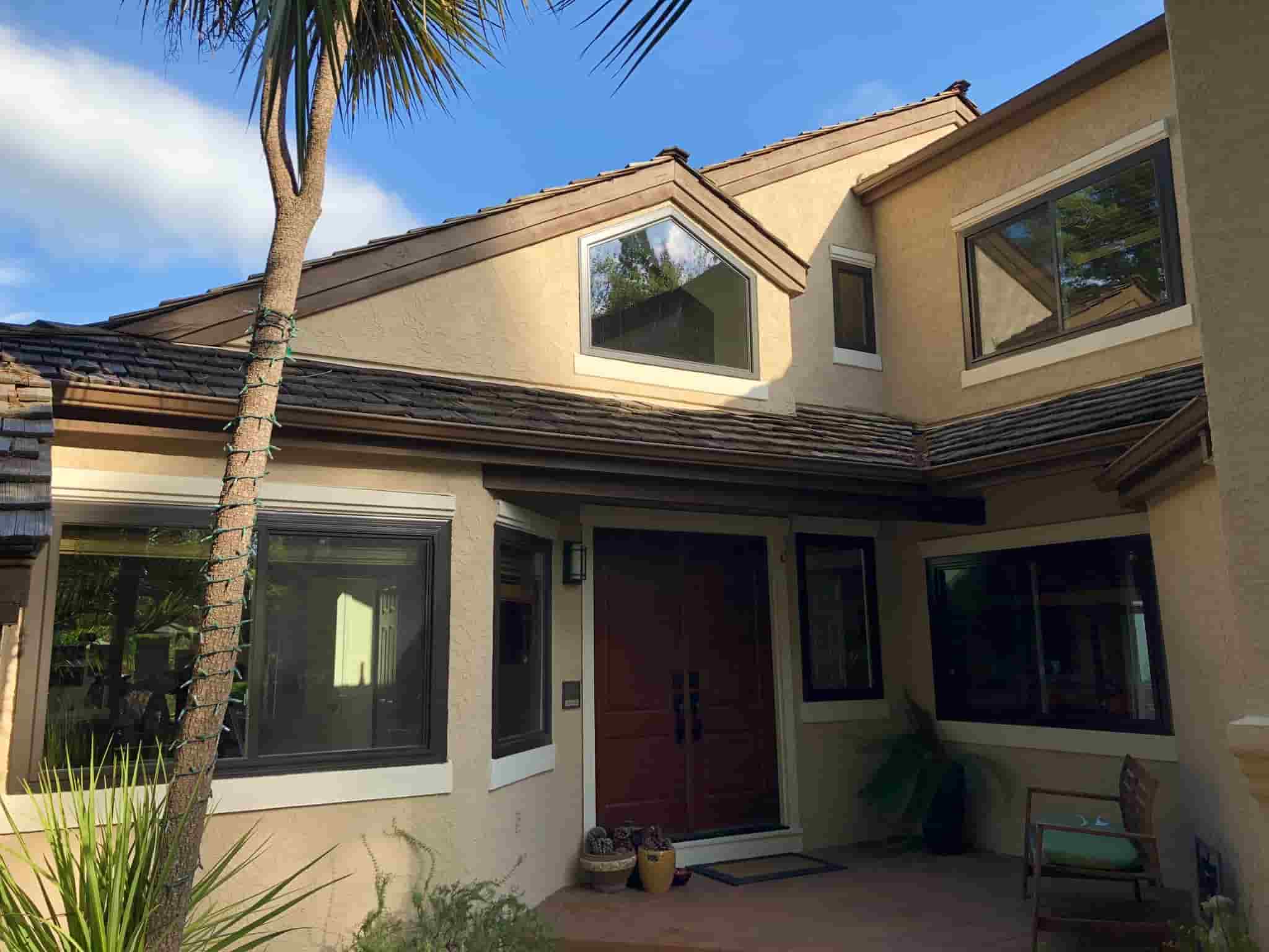 Modern residential home with newly installed black-framed energy-efficient windows and a custom geometric picture window by Best Exteriors.