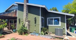 Green replacement siding with white trim and new windows on an Oakland, CA home.